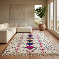 Ivory Azilal rug with magenta and blue diamond motifs in a sunlit boho living room