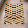 Azilal ivory wool rug with warm orange, olive and mustard chevron stripes, shown flat
