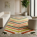 Ivory Azilal rug with warm zigzag stripes in a sunlit modern living room with armchair