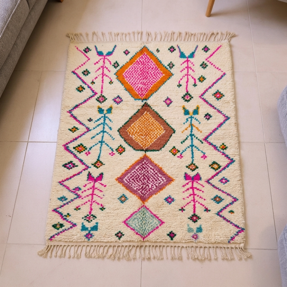 Azilal ivory wool rug with orange, pink and teal diamonds, zigzags and bird motifs, shown flat