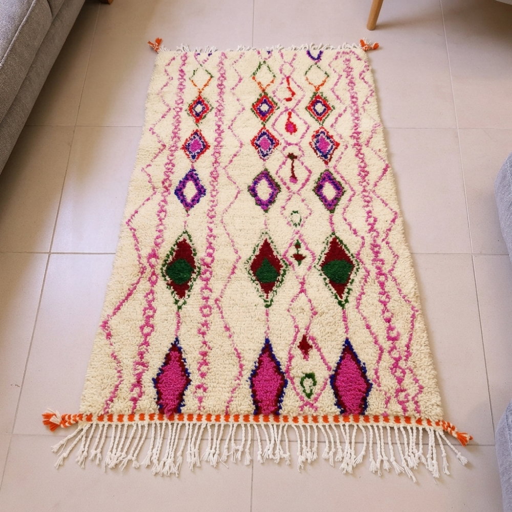Azilal ivory wool rug with an all-over pink diamond lattice and green-purple accents, shown flat