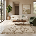 Ivory and brown Beni Ourain rug in a neutral living room with boucle sofa and green chair