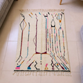 Beni Ourain ivory wool rug with abstract multicolor line motifs, shown flat