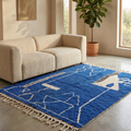 Majorelle blue Beni Ourain rug with ivory symbols in a bright contemporary room