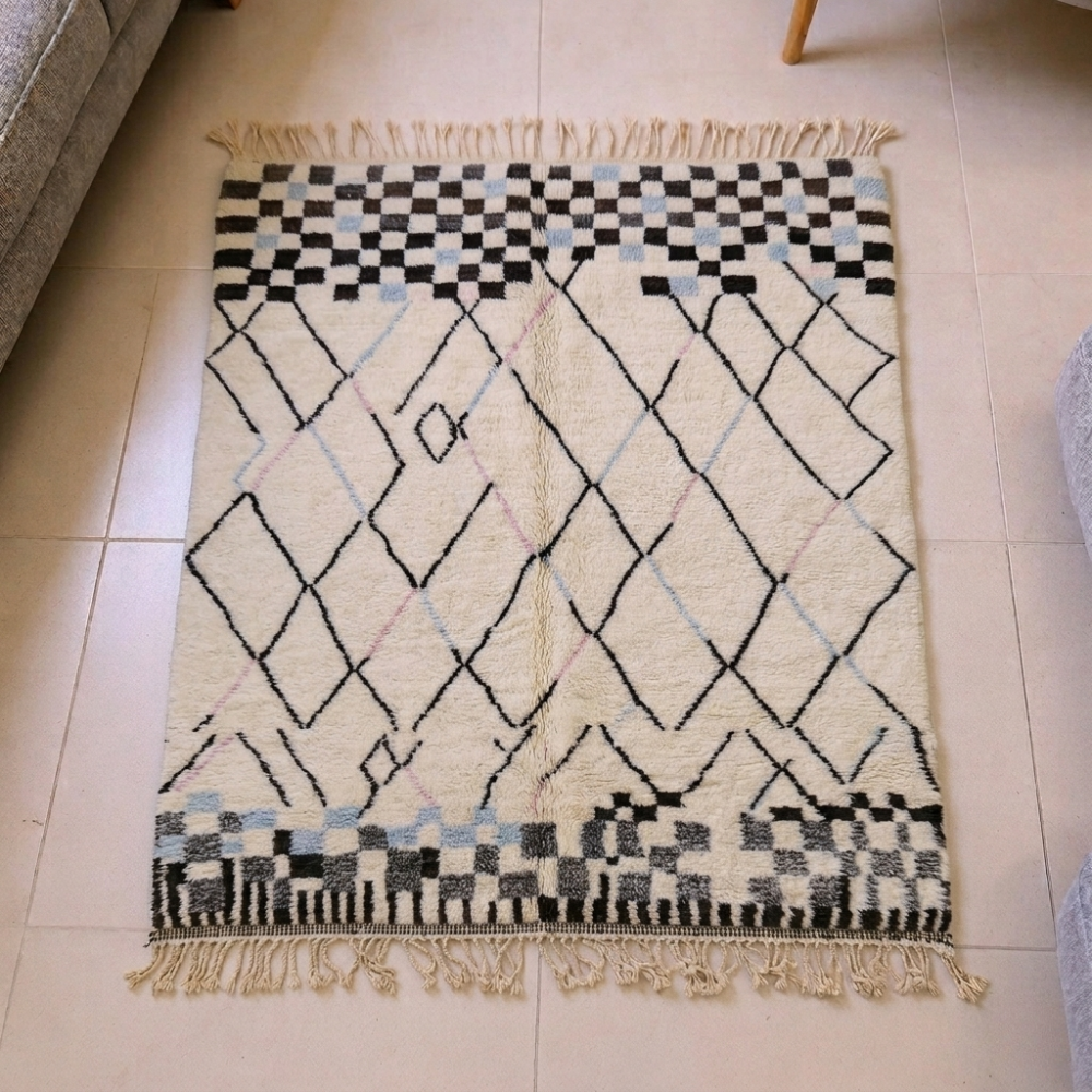 Mrirt ivory Beni Ourain wool rug with black diamond lattice and checkerboard bands, shown flat