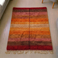 Mrirt sunset ombré plush wool rug with burgundy, rust and amber stripes, shown flat