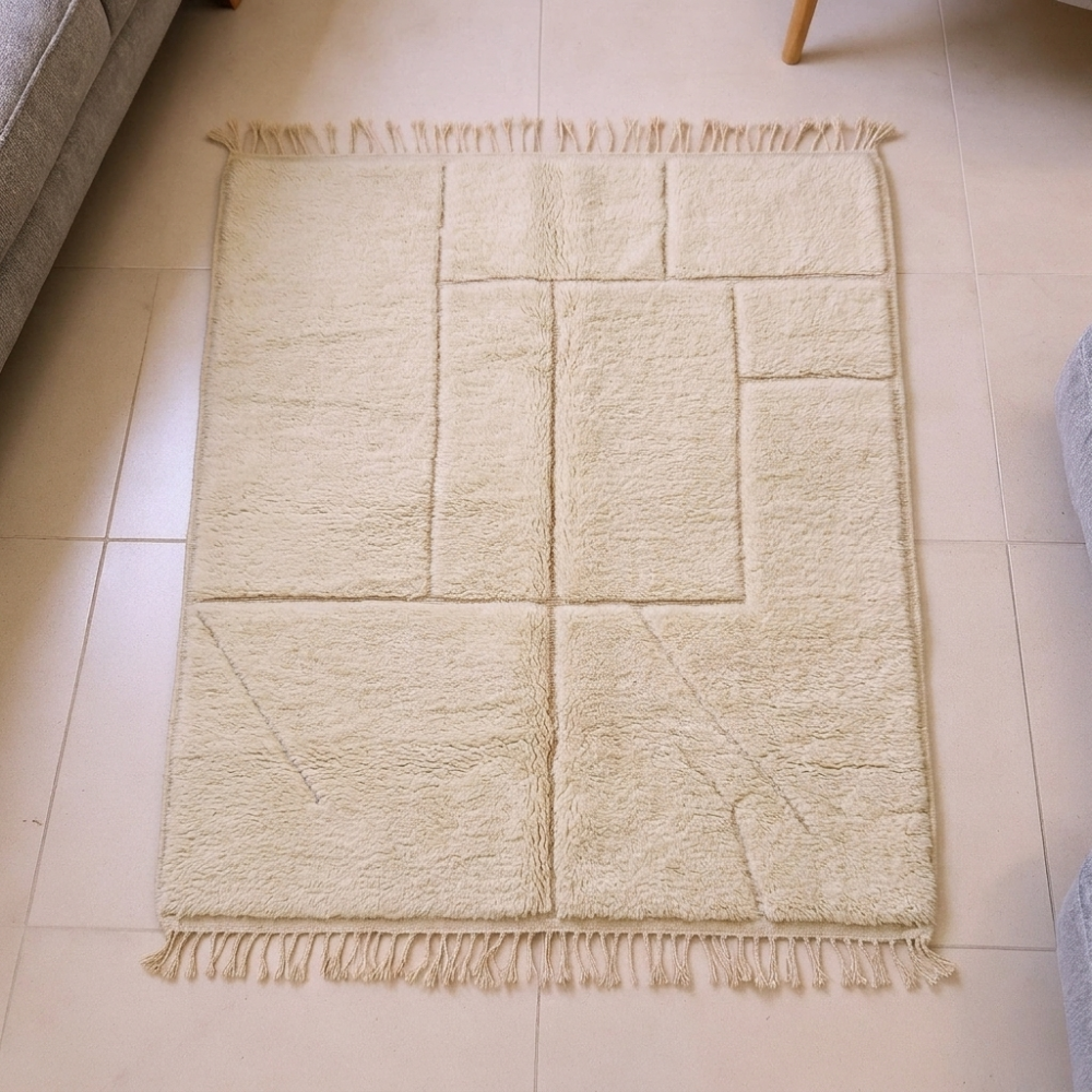 Mrirt ivory plush wool rug with subtle carved panel lines and fringe tassels, shown flat