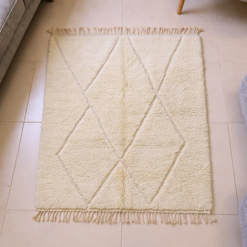 Mrirt ivory Beni Ourain wool rug with tonal diamond lozenge lattice and tassels, shown flat