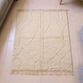 Mrirt ivory plush wool rug with bold black linear maze geometry, shown flat