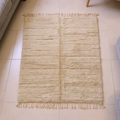 Mrirt ivory plush wool rug with carved grid and central column motif, shown flat