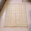 Mrirt ivory plush wool rug with carved grid and central keyhole motif, shown flat